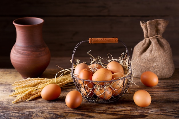 Uova fresche in un cestino sulla tavola di legno