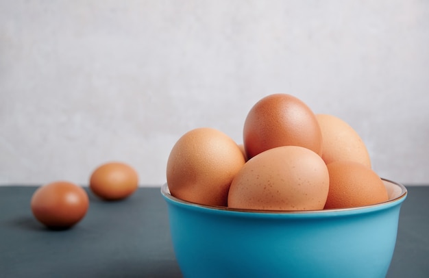 Fresh eggs in a blue bowl with copy space