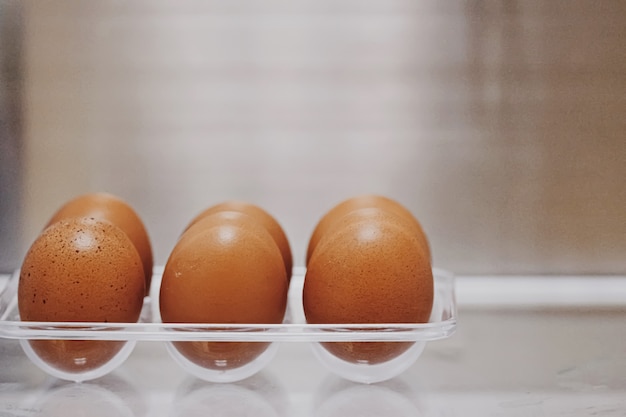 Fresh eggs in refrigerator, dairy product closeup