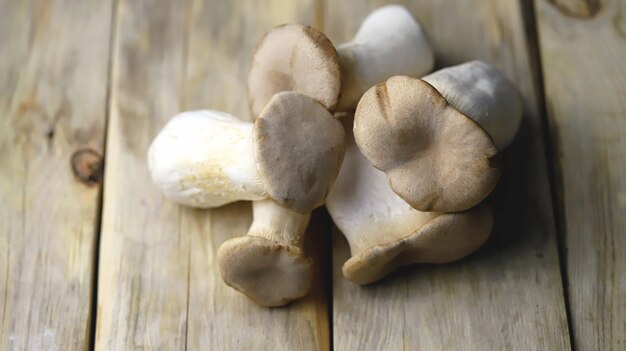 Fresh eringi mushrooms on a wooden surface