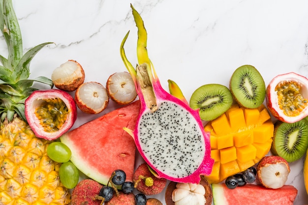 Fresh exotic fruits on white marble background