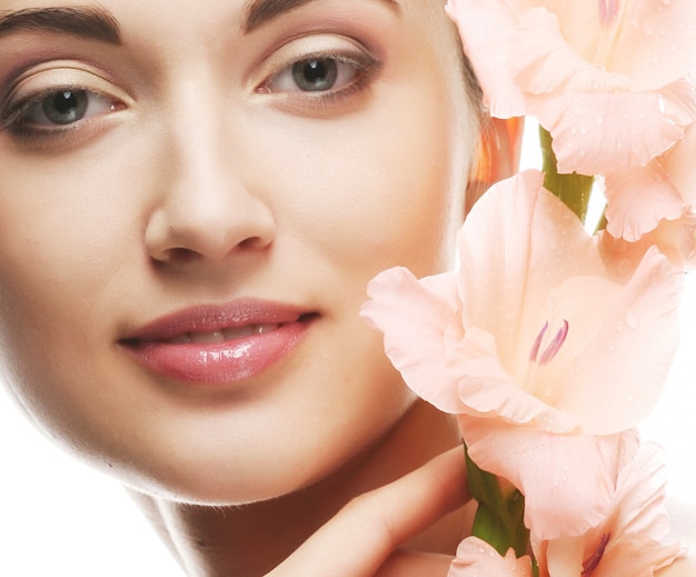 Fresh face with gladiolus flowers in her hands 