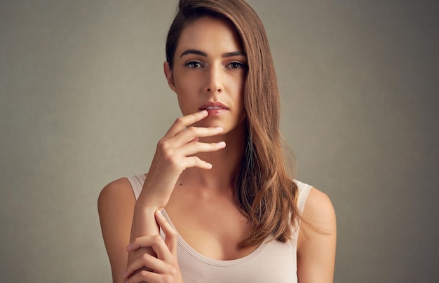 Fresh faced and beautiful Studio portrait of an attractive young woman standing against a brown background