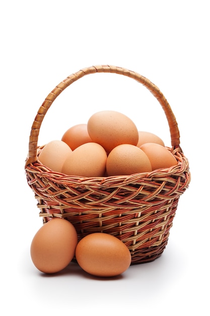 Fresh farm eggs in wicker basket isolated on white space