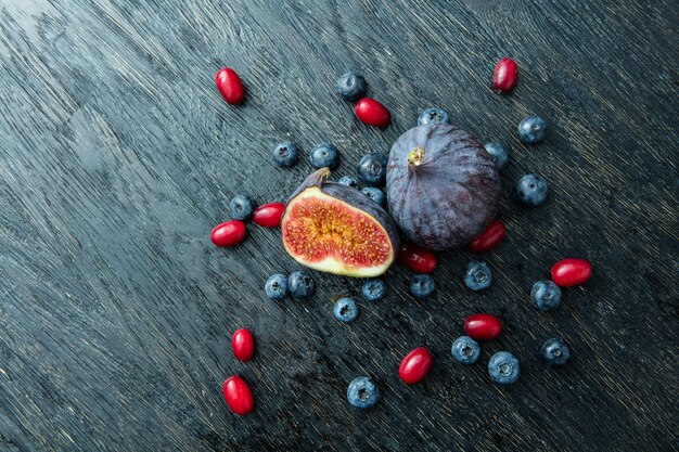 Fresh figs and blueberries on a gray wooden background