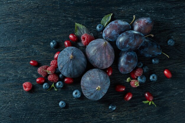 Fresh figs of different varieties berries on a dark wood table