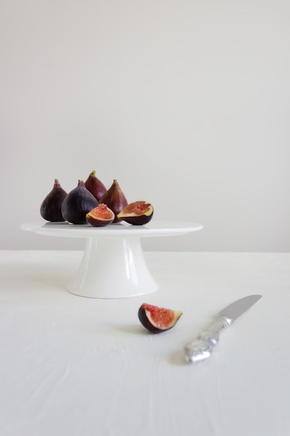 Photo fresh figs on the white stand with gray background