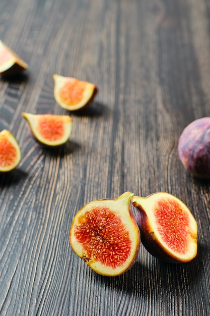 Fresh figs, whole and cut on slices on wooden table