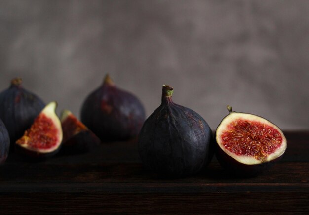 Fresh figs whole and in section on a wooden background closeup