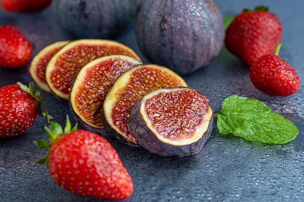 Fresh figs with strawberries on table
