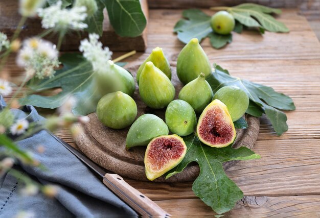 Fresh figs on wooden background with leaves