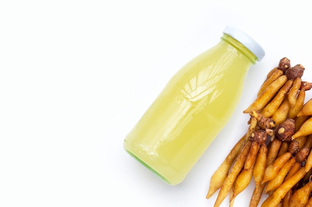 Fresh fingerroot with bottle of finger root juice on white background.