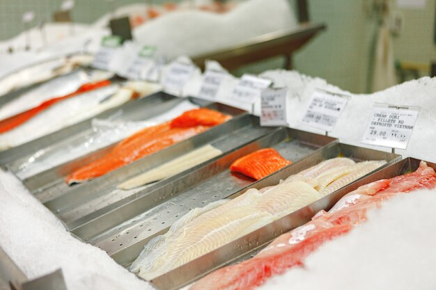 Fresh fish assorted on ice counter in supermarket