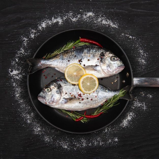 Fresh fish dorado Dorado and ingredients for cooking on a table