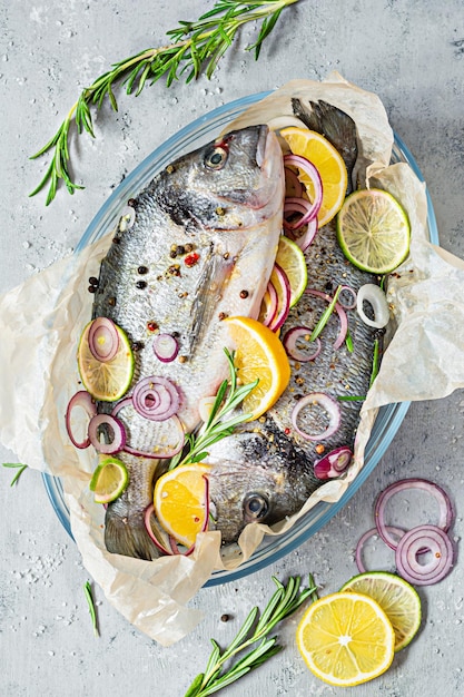 Fresh fish dorado. Raw dorado with herbs, spices and lemon and lime slices ready to cook