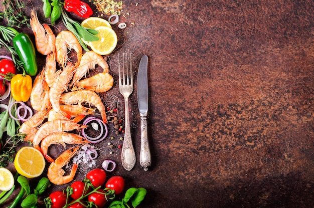 어두운 빈티지 배경에 허브 향신료와 야채를 곁들인 신선한 생선 새우 건강 식품 다이어트 또는 요리 개념
