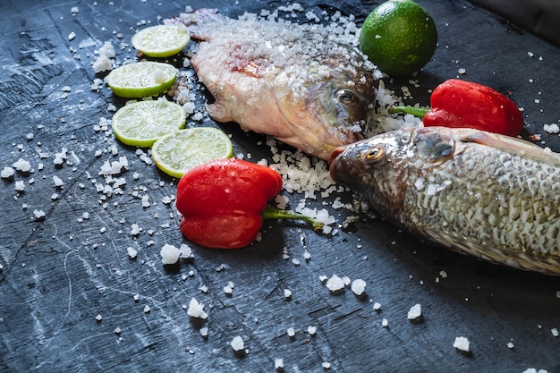 Fresh fish of tilapia with salt and seasoning for cooking.