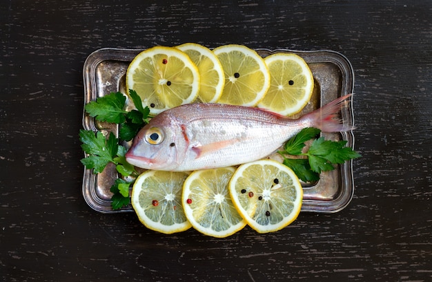 Photo fresh fish with lemon slices and parsley