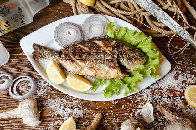 Fresh Fish With Lemons and Garlic on a Plate