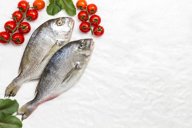 Foto pesce fresco con pomodori rossi e peperoncini sfondo bianco deposizione piatta spazio di copia