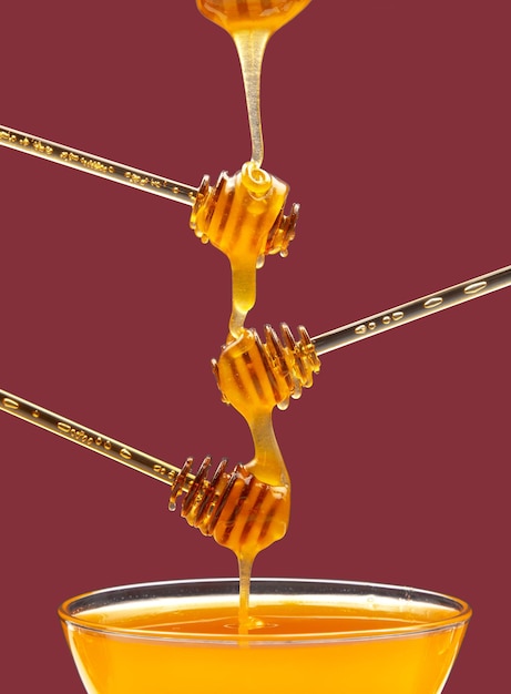 Fresh floral honey drips from a spoon into a spoon on a colored background Organic vitamin food