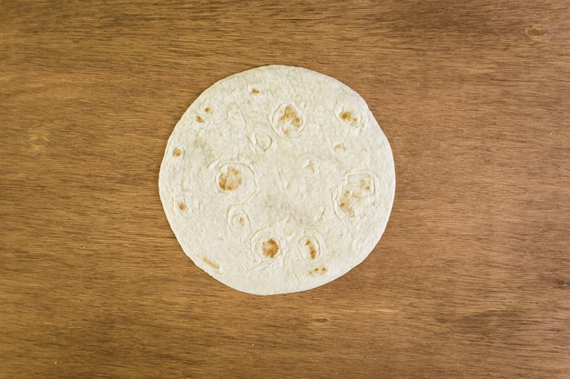 Fresh flour tortillas on a wood background.