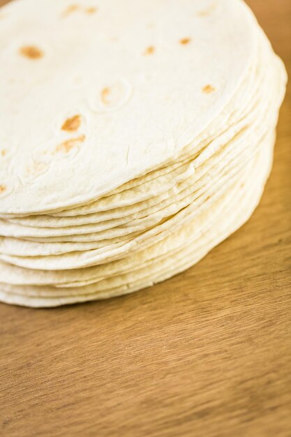 Fresh flour tortillas on a wood background.