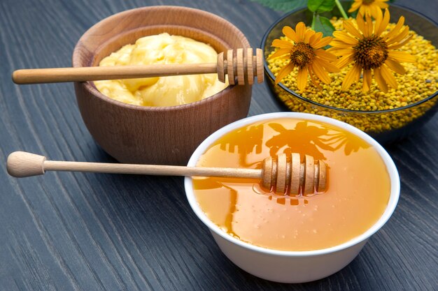 Fresh flower honey of different varieties, pollen and honeycomb with spoons on a wooden background. Organic Vitamin Health Food