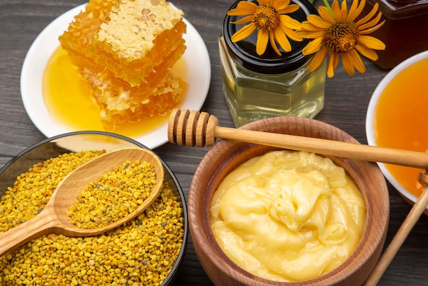 Fresh flower honey of different varieties, pollen and honeycomb with spoons on a wooden background. Organic Vitamin Health Food