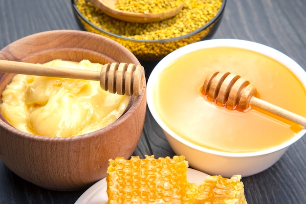 Fresh flower honey of different varieties pollen and honeycomb with spoons on a wooden background Organic Vitamin Health Food