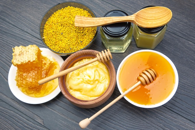 Свежий цветочный мед разных сортов пыльца и соты с ложками на деревянном фоне Органический витамин Здоровая пища