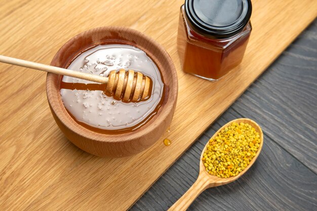 Fresh flower honey of different varieties, pollen with spoons on a wooden background. Organic Vitamin Health Food