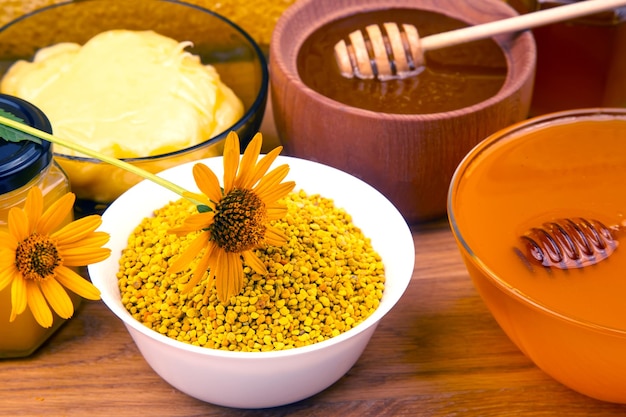 건강과 생명을 위한 나무 그릇 숟가락과 벌집 비타민 식품에 신선한 꽃 꿀