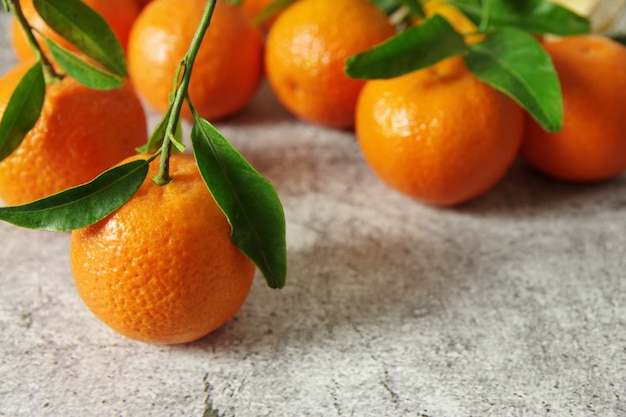 Fresh fragrant tangerines with green leaves on the table