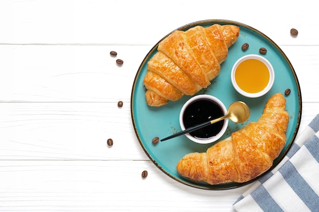 Fresh french croissants with chocolate on blue plate