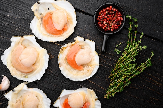 Photo fresh french scallops seafood market set on black wooden table background top view flat lay