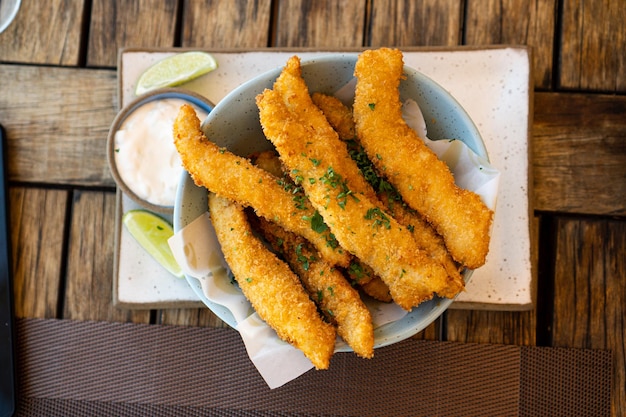 Photo fresh fried brazilian tilapia fish strips with lime and tartar sauce known as isca de peixe traditional brazilian appetizer selective focus