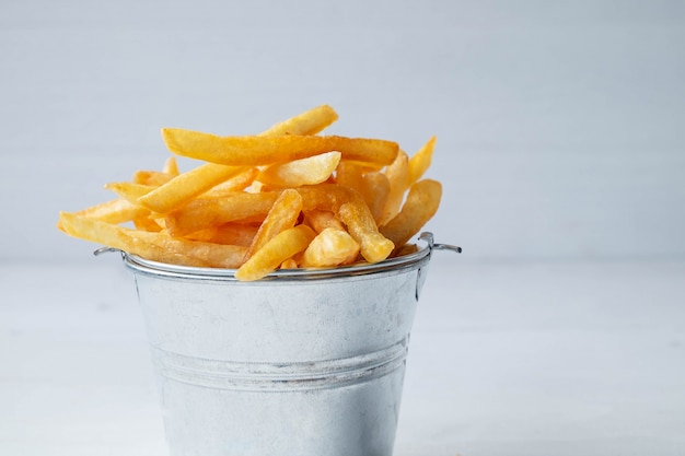 Fresh fried french fries on white wooden table