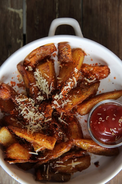 Foto patatine fritte fresche con ketchup su fondo di legno