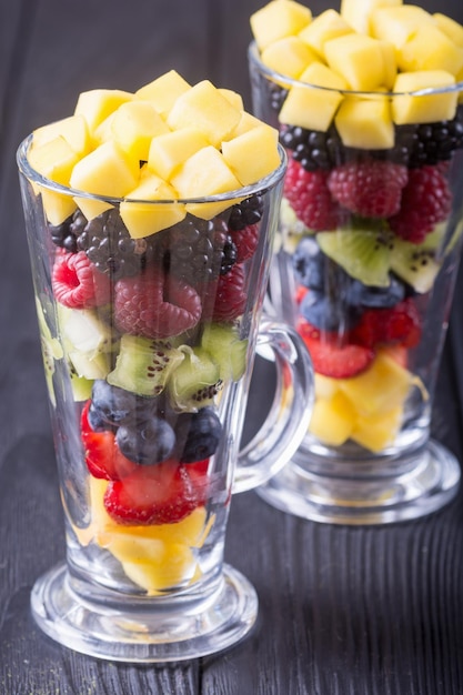 Fresh fruit and berries salad in glass Healthy vitamin food background