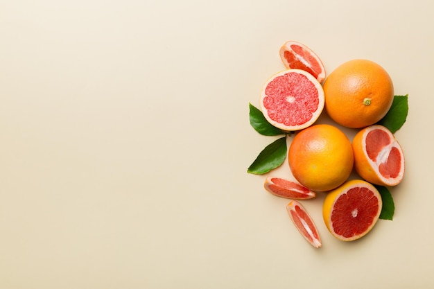 色付きの背景にジューシーなグレープフルーツスライスとフレッシュフルーツグレープフルーツ上面図コピースペース創造的な夏のコンセプト最小限のフラットで柑橘類の半分はコピースペースで横たわっていた