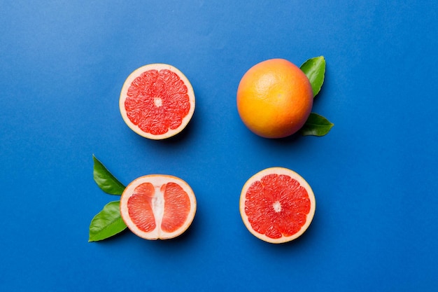 Fresh Fruit grapefruit with Juicy grapefruit slices on colored background Top view Copy Space creative summer concept Half of citrus in minimal flat lay with copy space