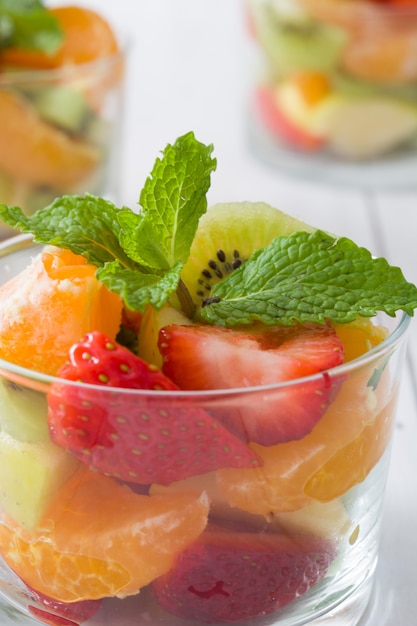 Fresh fruit salad in glass on wooden table