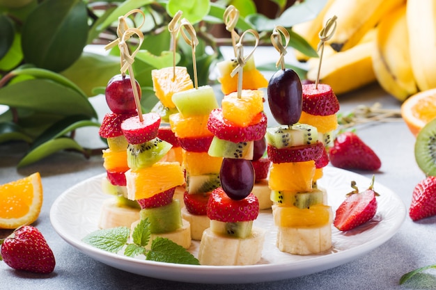 Photo fresh fruit on skewers. concept buffet for a summer party.