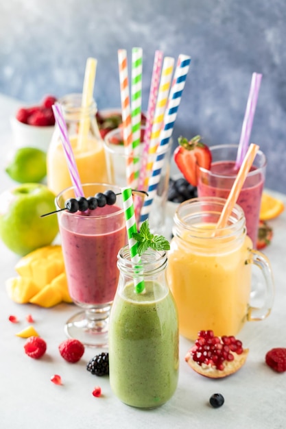 Photo fresh fruit smoothies with colourful straws ready for drinking