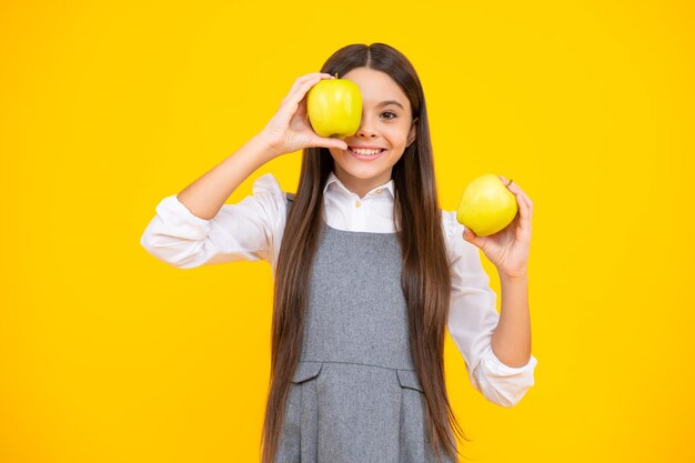 Fresh fruit teenager girl hold apples on yellow isolated studio background child nutrition