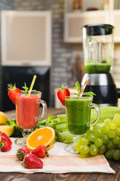 Foto frullato di frutta e verdura fresca sul tavolo da cucina in vetro