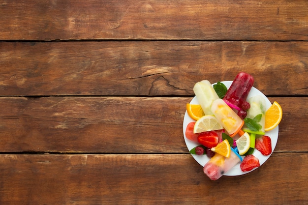 Frutta fresca su un piatto bianco e fondo in legno