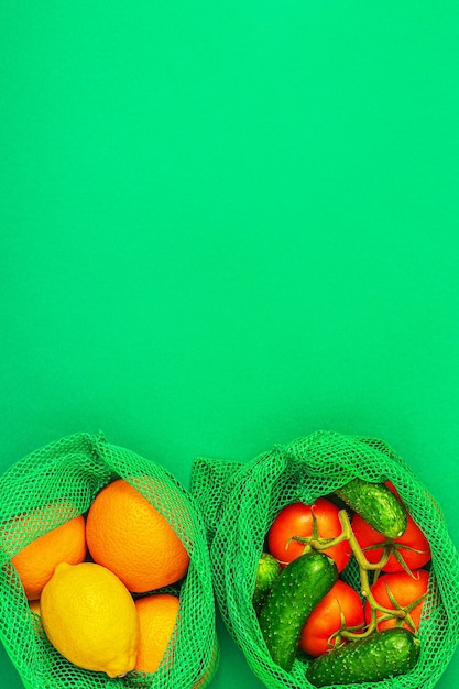 Свежие фрукты и овощи в многоразовых мешках из текстильной сетки, экологически чистые покупки, концепция безотходного использования.