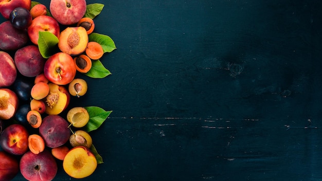 Frutta fresca. albicocca, pesca, prugna, nettarine. su uno sfondo di legno. vista dall'alto. spazio libero per il tuo testo.